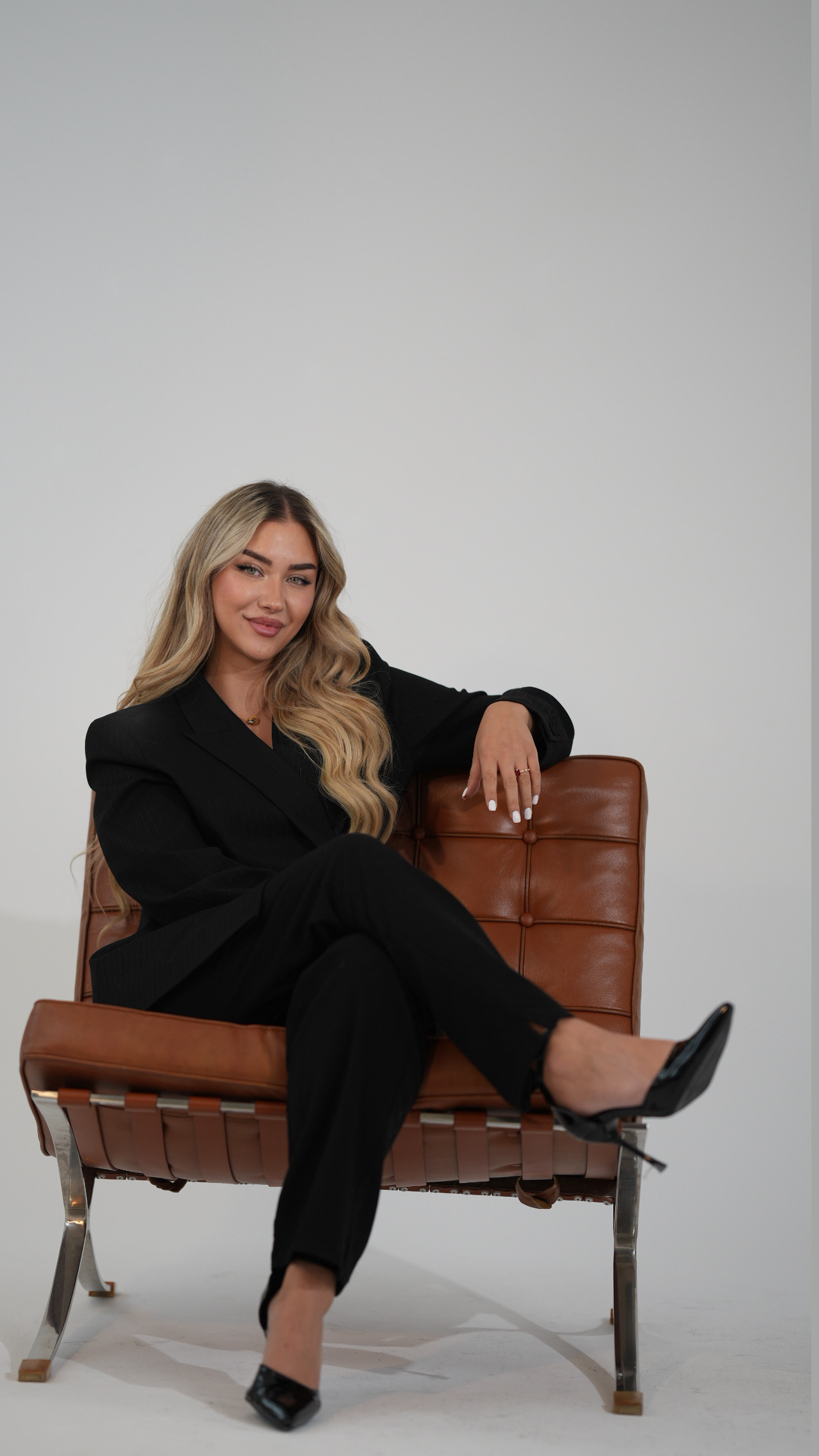 ECE Demirci seated in a brown leather chair